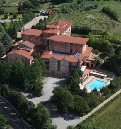 Vista aerea di un elegante hotel con piscina immerso nella natura rigogliosa.