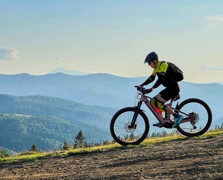 Ciclista in montagna, pedalando su un sentiero con vista panoramica.