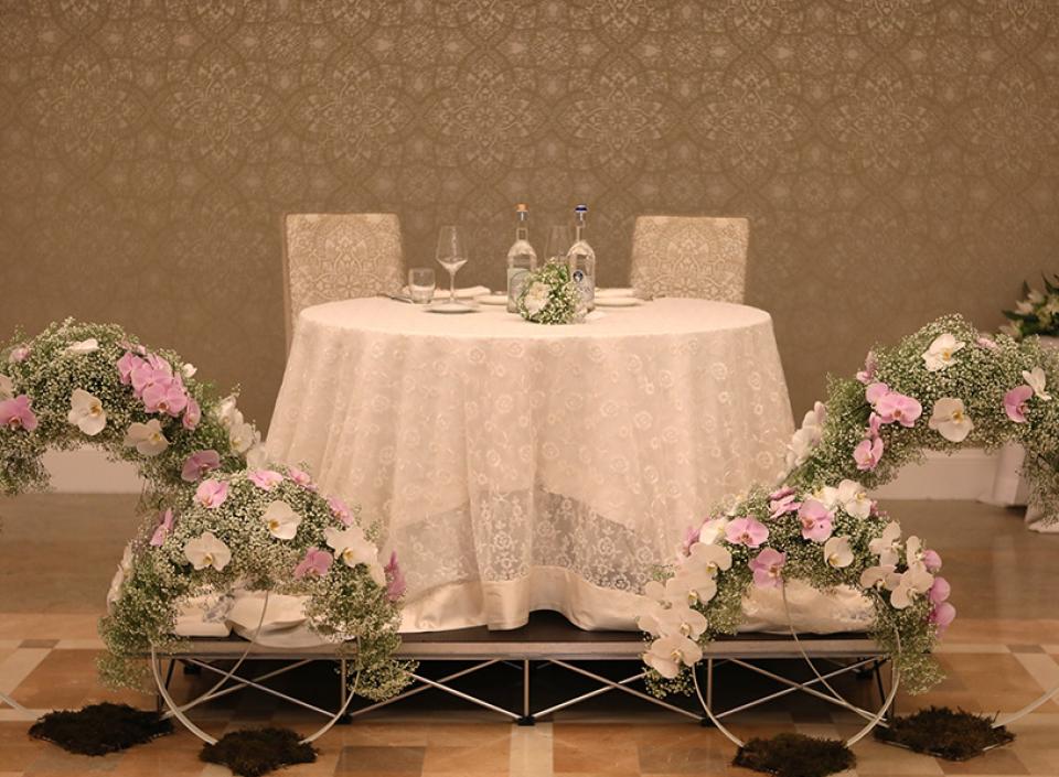 Tavolo elegante con fiori bianchi e rosa, atmosfera romantica e raffinata.