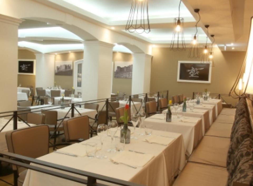 Ristorante elegante con tavoli apparecchiati, illuminazione moderna e atmosfera accogliente.