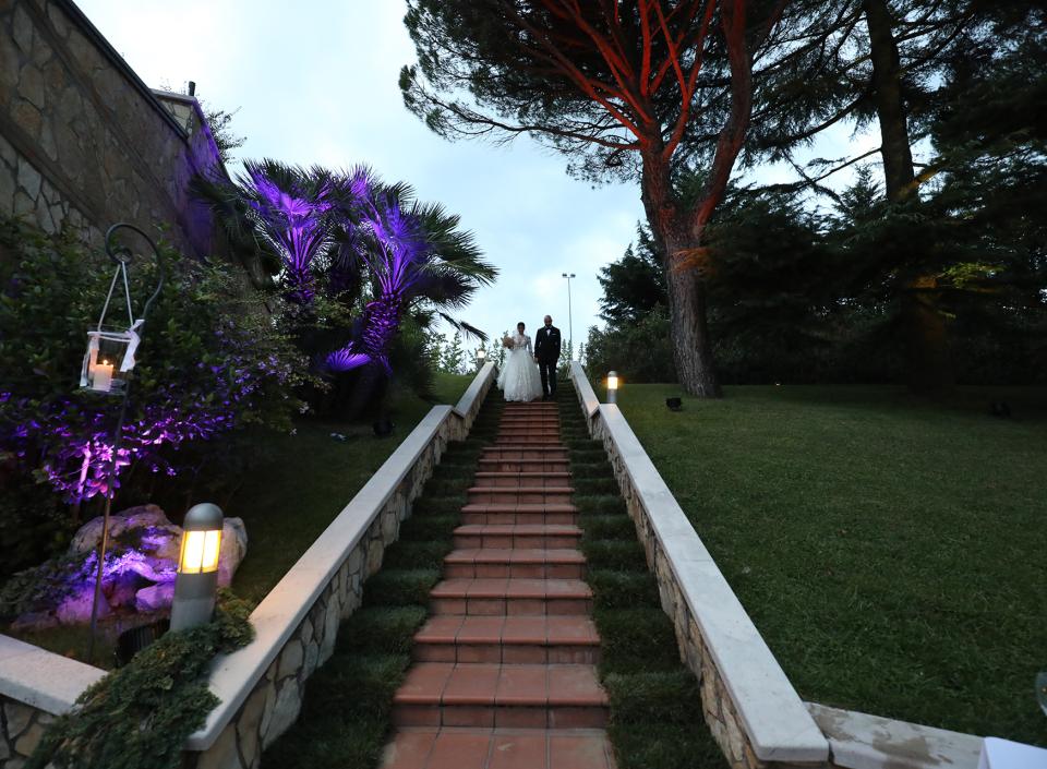 Una coppia di sposi felici cammina tra gli applausi degli invitati al matrimonio.