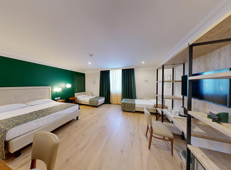 Camera spaziosa, elegante, con letti accoglienti e arredi moderni, atmosfera calda e rilassante.